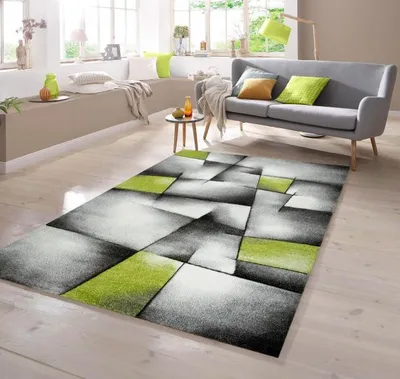 A modern living room with a gray sofa, a small side table, and a geometric rug.