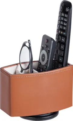 A brown leather organizer with two remote controls and a pair of glasses inside, shown against a white background.