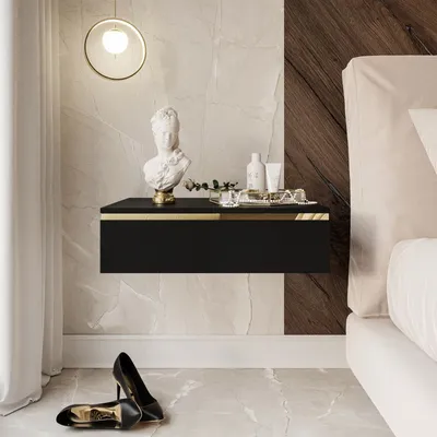 A modern bedroom scene featuring a black floating nightstand with gold accents, a bust sculpture, and toiletries.