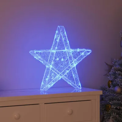 A lit-up star decoration sits on top of a white dresser, next to a decorated Christmas tree.