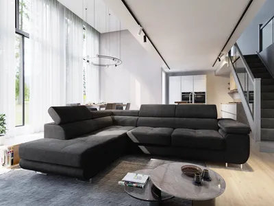 A modern living room with a large sectional sofa, coffee table, and stairs leading to an upper level.