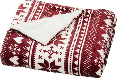 A folded blanket with a red and white Nordic pattern and a white sherpa lining.