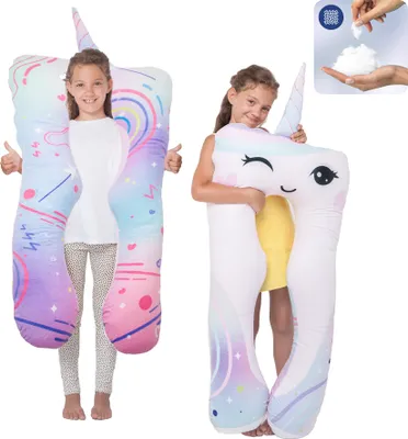 Two young girls are posing with large unicorn-shaped pillows.