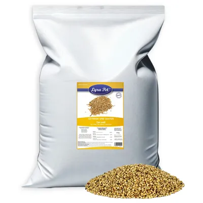 A large white bag of birdseed with a pile of birdseed in front of it. A label is attached to the bag.