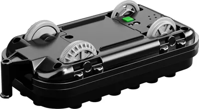 The underside of a toy train locomotive with wheels and a green button.
