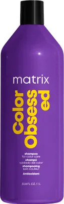 A studio shot of a large purple bottle of Matrix Total Results Color Obsessed Shampoo.