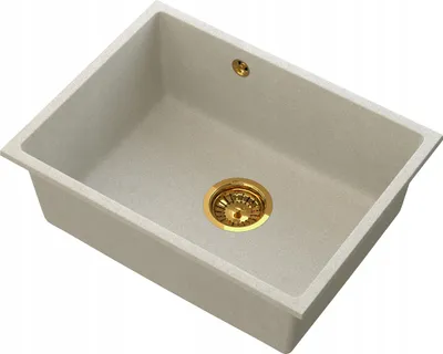 A beige sink with gold fixtures against a white background.