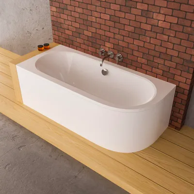 A white bathtub with silver fixtures is placed on a wooden platform, with a brick wall in the background.