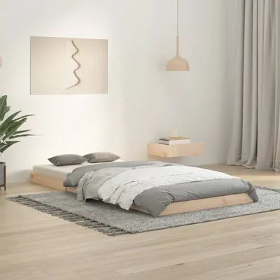 A bedroom scene with a wooden bed frame and bedding.