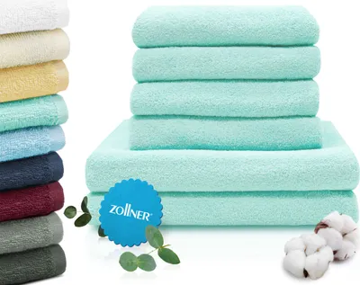 A stack of folded towels in various colors, with a prominent stack of turquoise towels in the foreground.