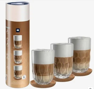 A cylindrical product packaging and three glasses filled with coffee and foam are displayed against a white background.
