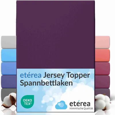 A product image showing a purple fitted sheet with stacks of sheets in various colors on either side, and cotton bolls at the bottom.