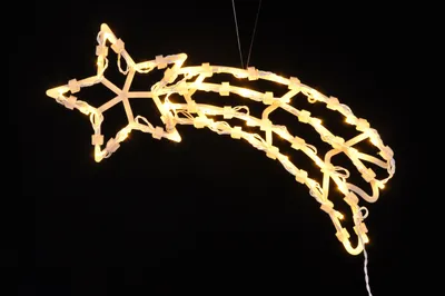 A decorative shooting star light decoration against a black background.