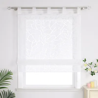 A white Roman blind with a branch pattern hangs on a window.