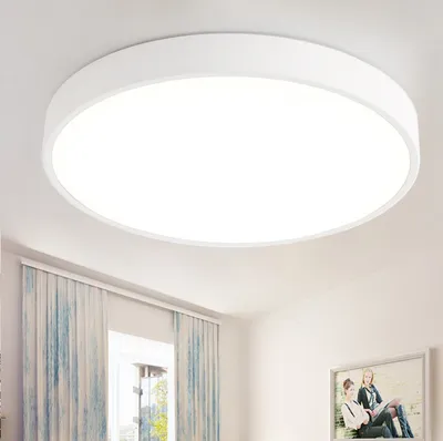 A white, circular LED ceiling light is shown mounted on a white ceiling.