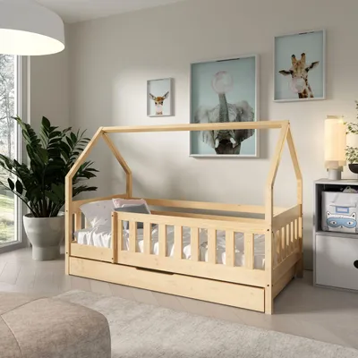 A child's bedroom with a wooden house bed, a plant, and artwork on the wall.