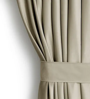 A close-up view of a beige curtain with a pleat and a tie-back.
