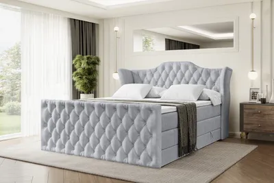 A bedroom scene with a large, upholstered bed as the main focus.