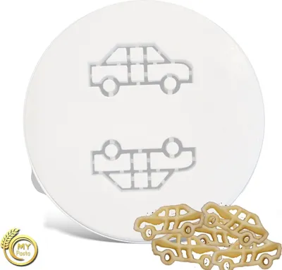 A white circular pasta cutter with car shapes impressed onto it, with some car-shaped pasta pieces scattered at the bottom right.