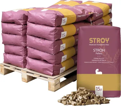 A pallet of bagged straw pellets with a single bag and a pile of pellets in the foreground.