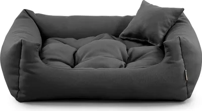A dark gray dog bed with a small pillow on a white background.