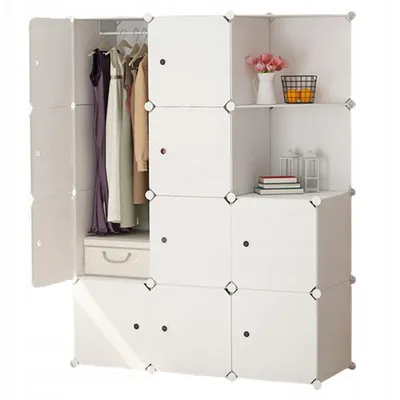A modular wardrobe with clothes hanging inside and decorative items on a shelf.