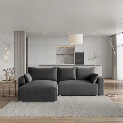 A modern living room scene featuring a dark gray sectional sofa in front of a minimalist kitchen area.