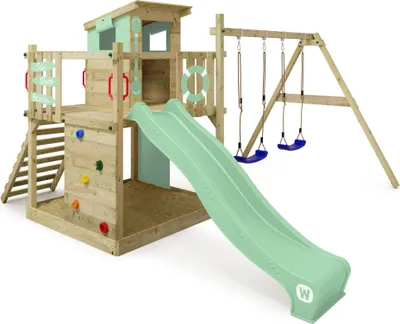 A wooden playground set with a slide, swings, climbing wall, and sandpit.