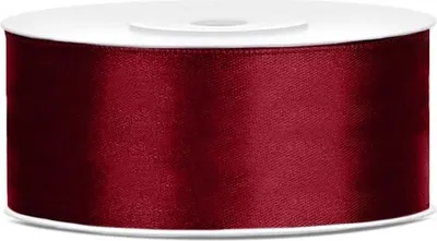 A roll of burgundy satin ribbon on a white spool.