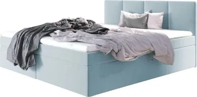 A light blue upholstered bed with a headboard, made up with bedding and pillows.