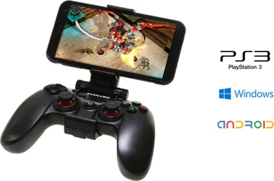A black game controller with a smartphone attached, displaying a game. Logos for PS3, Windows, and Android are visible on the right.