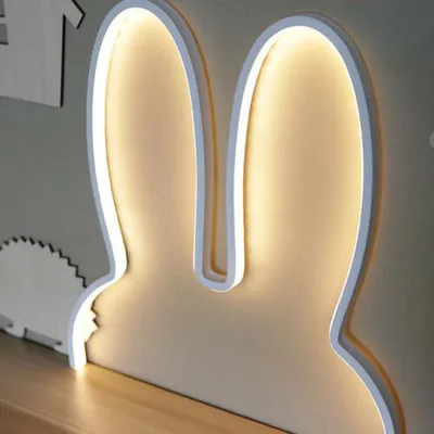 A close-up shot of a bunny ear-shaped night light, illuminated from behind.