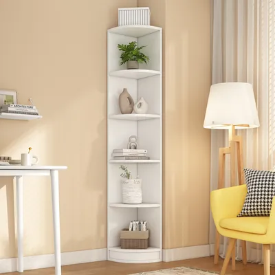 A white corner bookshelf with decorative items on a light beige wall.