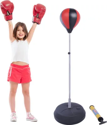 A young girl in boxing gloves and shorts stands with her arms raised next to a punching bag set. A pump is also visible.