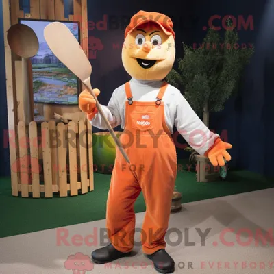 Obrázok produktu pre Kostýmová postava REDBROKOLY, maskot Peach Knife Thrower, oblečená v pracovných nohaviciach (dungarees) a návlekoch na topánky