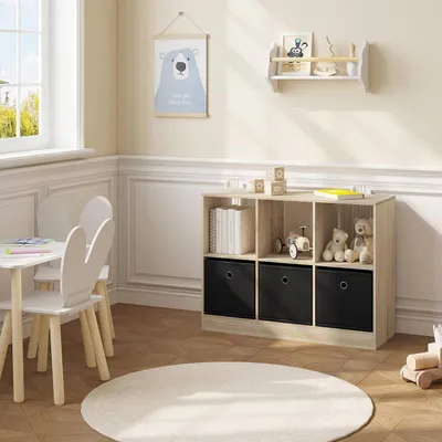 A child's room with a small table and chairs, a bookshelf, and a round rug.