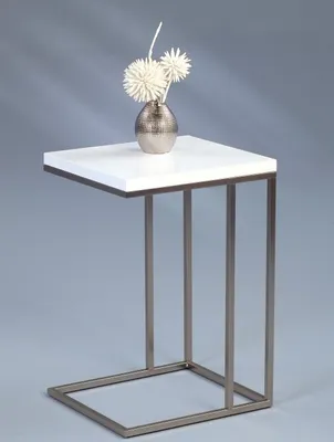 A white side table with a metallic vase and decorative flowers on top, set against a plain gray background.