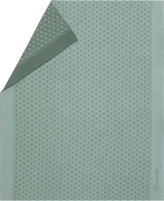 A folded green blanket with a subtle geometric pattern.