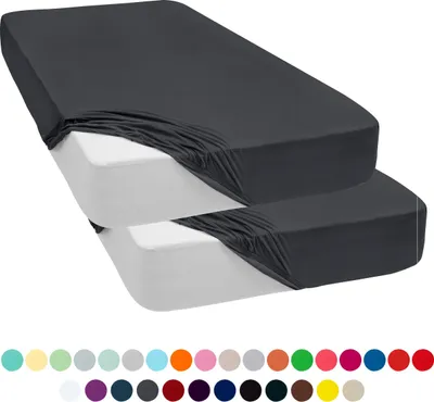 Two fitted sheets are stacked on top of each other, with the top sheet being a dark gray and the bottom sheet being white. Below the sheets is a row of colored circles, likely representing color options.