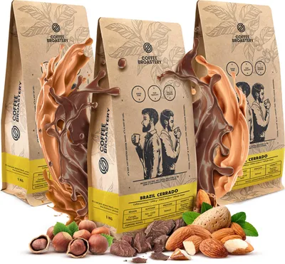 Three bags of coffee beans are displayed with splashes of chocolate and nuts in the foreground.