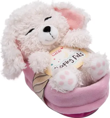 A white plush dog toy with pink accents, sleeping in a pink basket, with a product tag attached.
