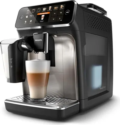 A close-up studio shot of a black and silver Philips automatic coffee machine with a glass of latte in the foreground.