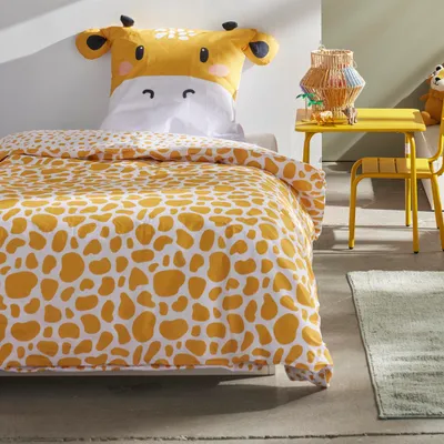 A child's bedroom with a giraffe-themed bed and a small yellow table and chair.