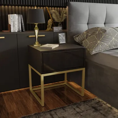 A bedside table next to a bed in a bedroom.
