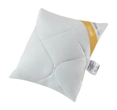 A white quilted pillow with a yellow and white tag on the side.