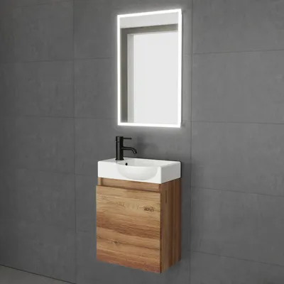 A modern bathroom vanity set with a sink, faucet, and illuminated mirror against a tiled wall.