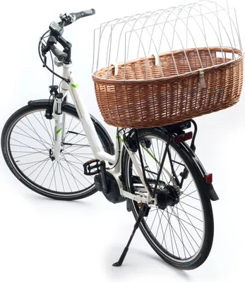 A white electric bicycle with a large wicker basket mounted on the rear rack, against a white background.