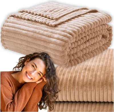 A woman smiling and resting her head on her hands, with a folded beige blanket in the background and a close-up of the blanket texture in the lower right corner.