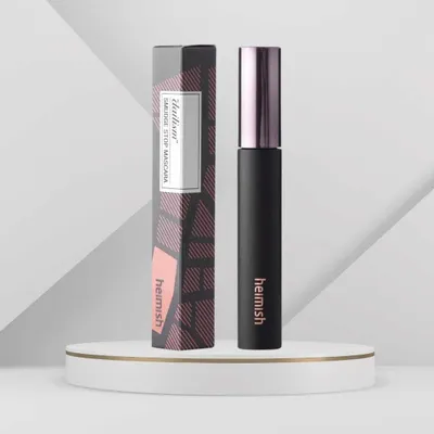 A mascara product and its packaging are displayed on a white pedestal against a light gray background.