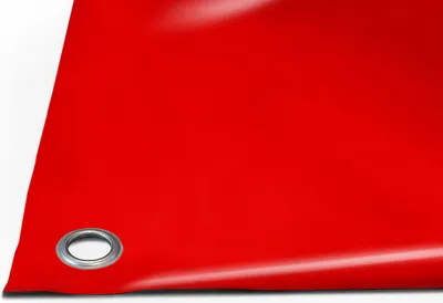 A close-up view of a red PVC truck tarp with a metal grommet.